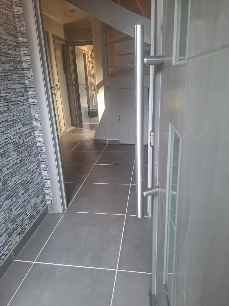 Renovatie inkomhal met natuursteen en tegelvloer